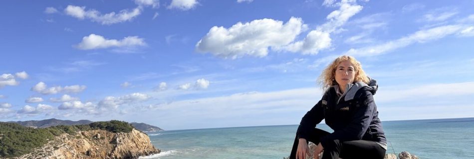 Cris sentada en unas rocas junto al mar