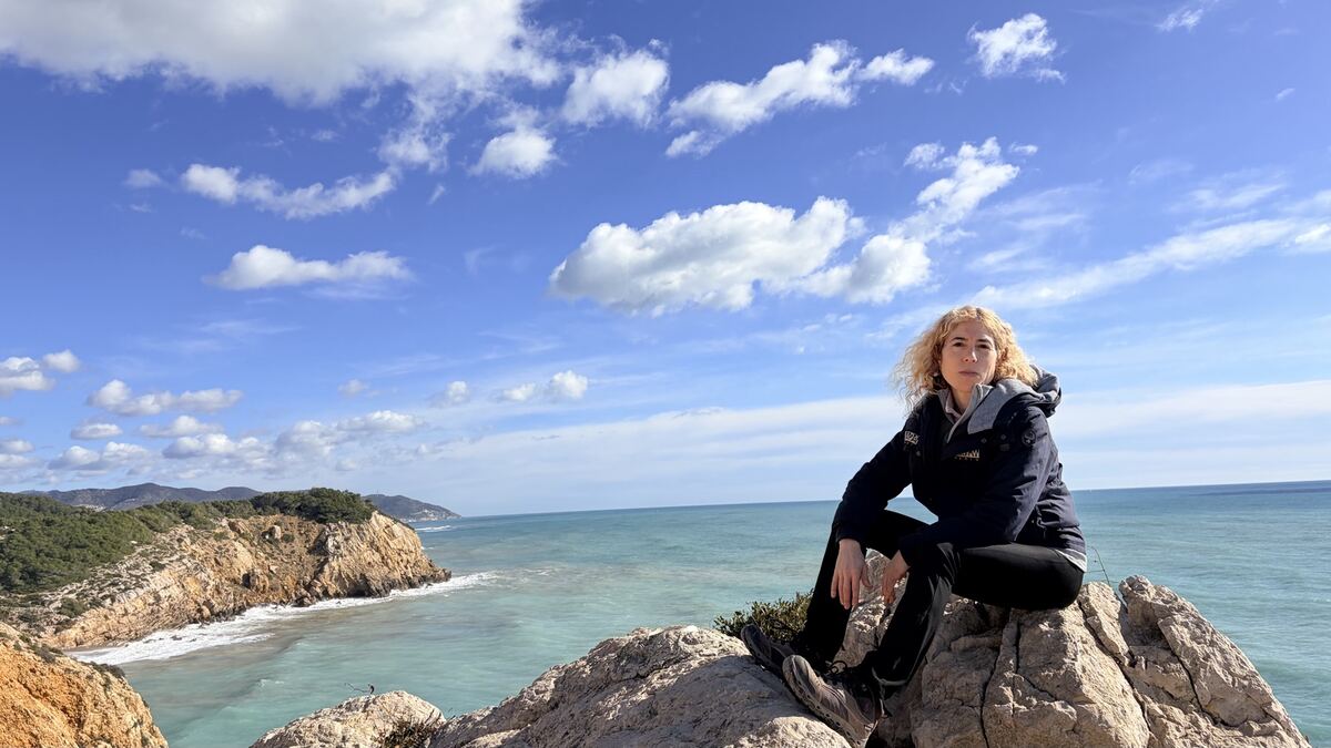 Cris sentada en unas rocas junto al mar